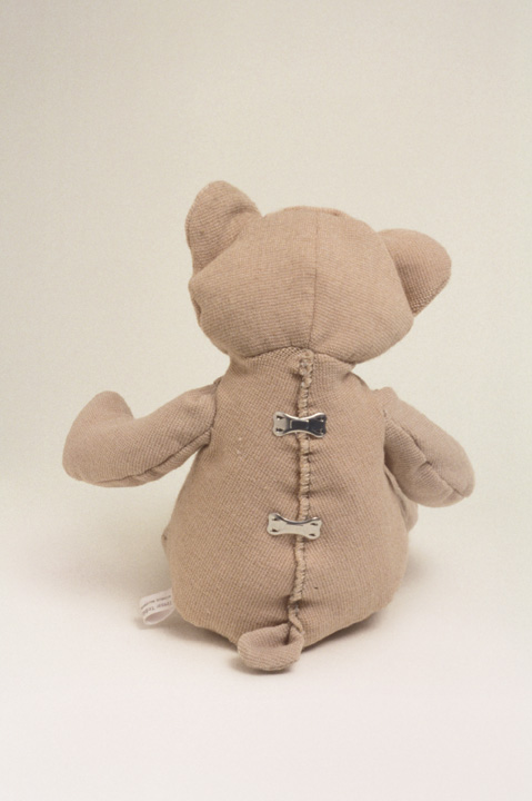 Back view of a stuffed bear stitched together with metal brackets