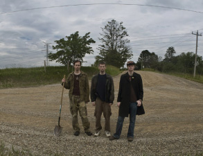 three men standing in a farmer's field