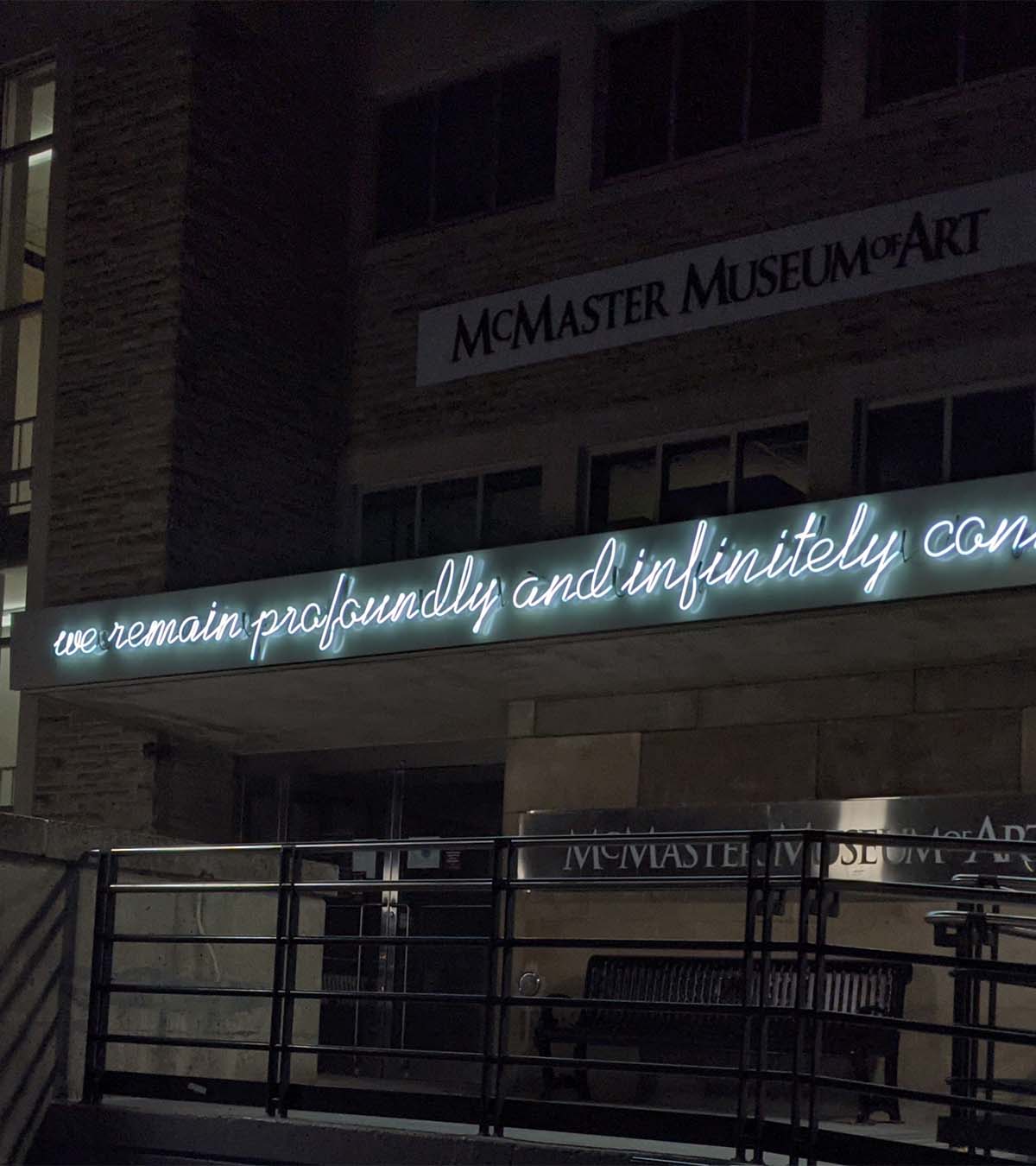 Detail of neon sculpture that reads 'we remain profoundly and infinitely connected' on the facade of the museum
