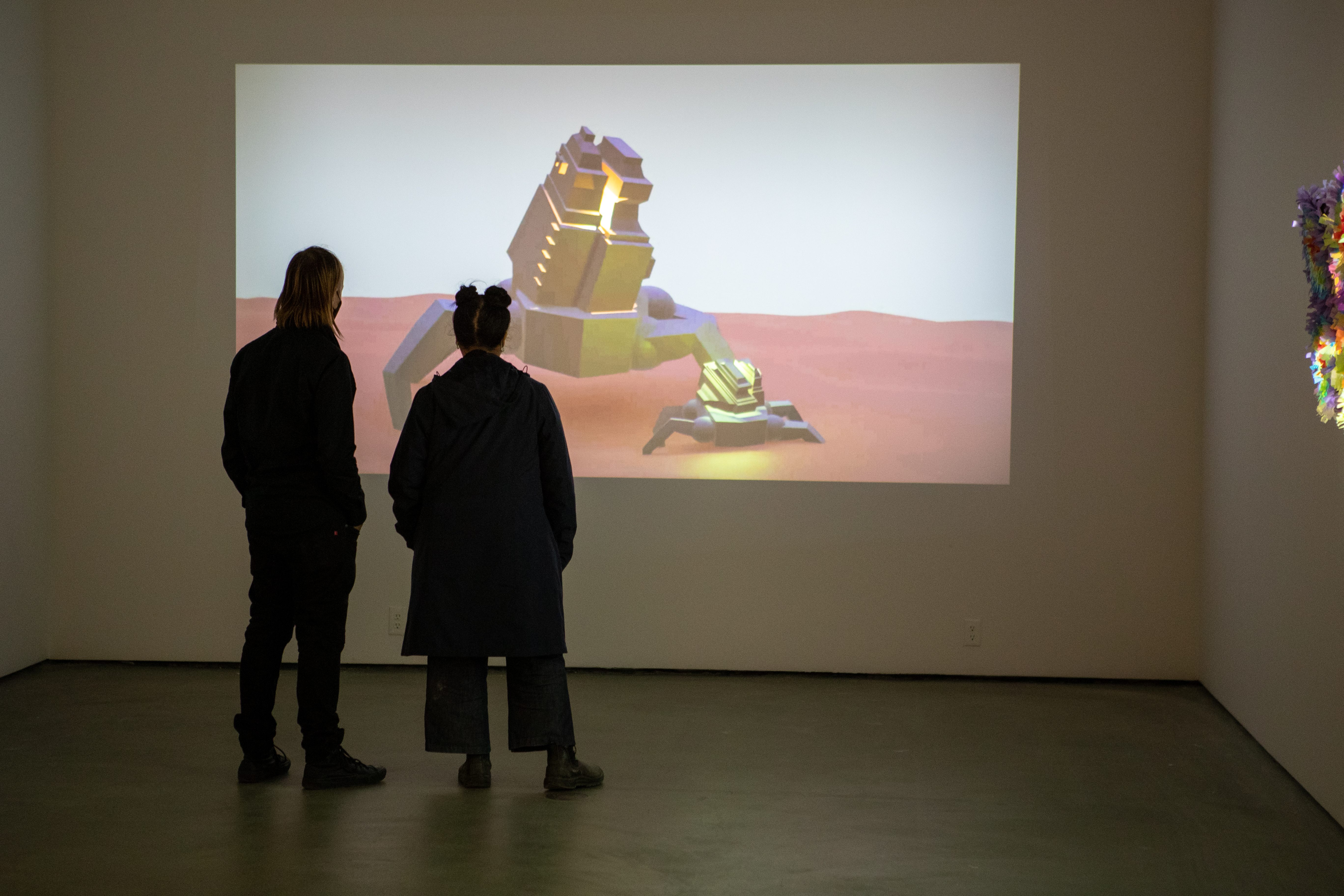 Two people looking at a video projected on the wall