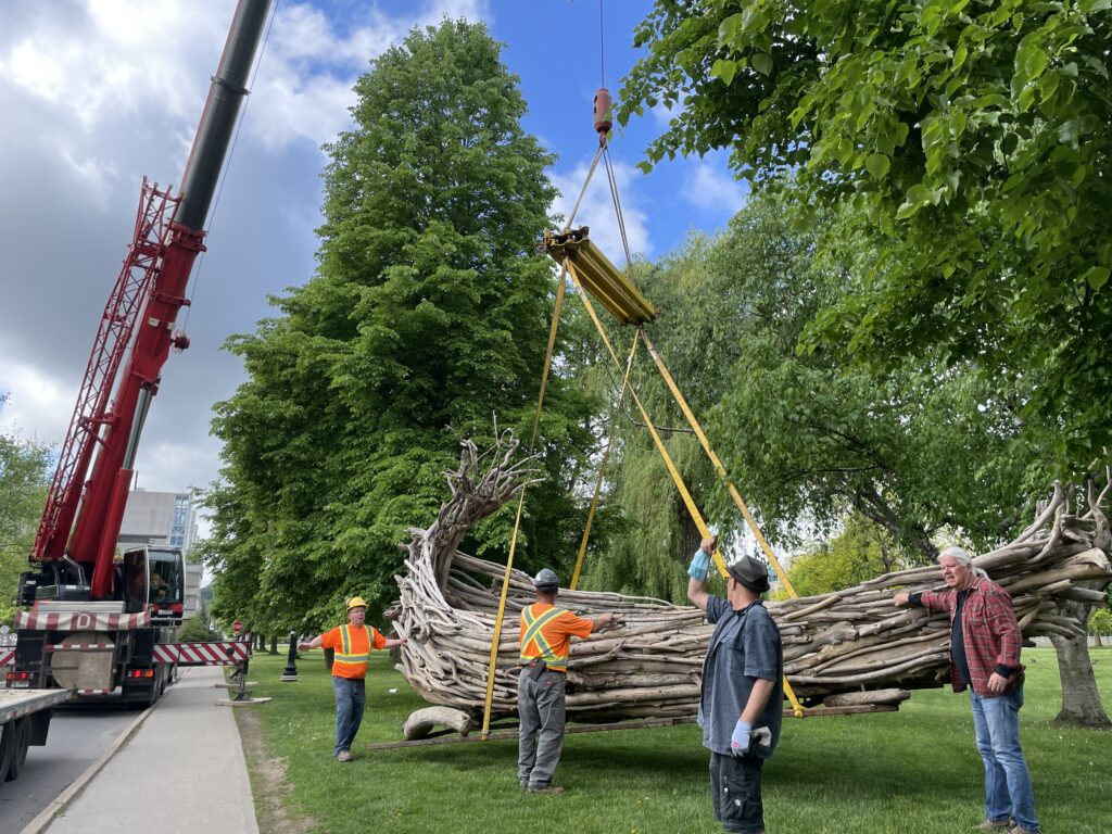 A large crane drops The Boat Project on campus